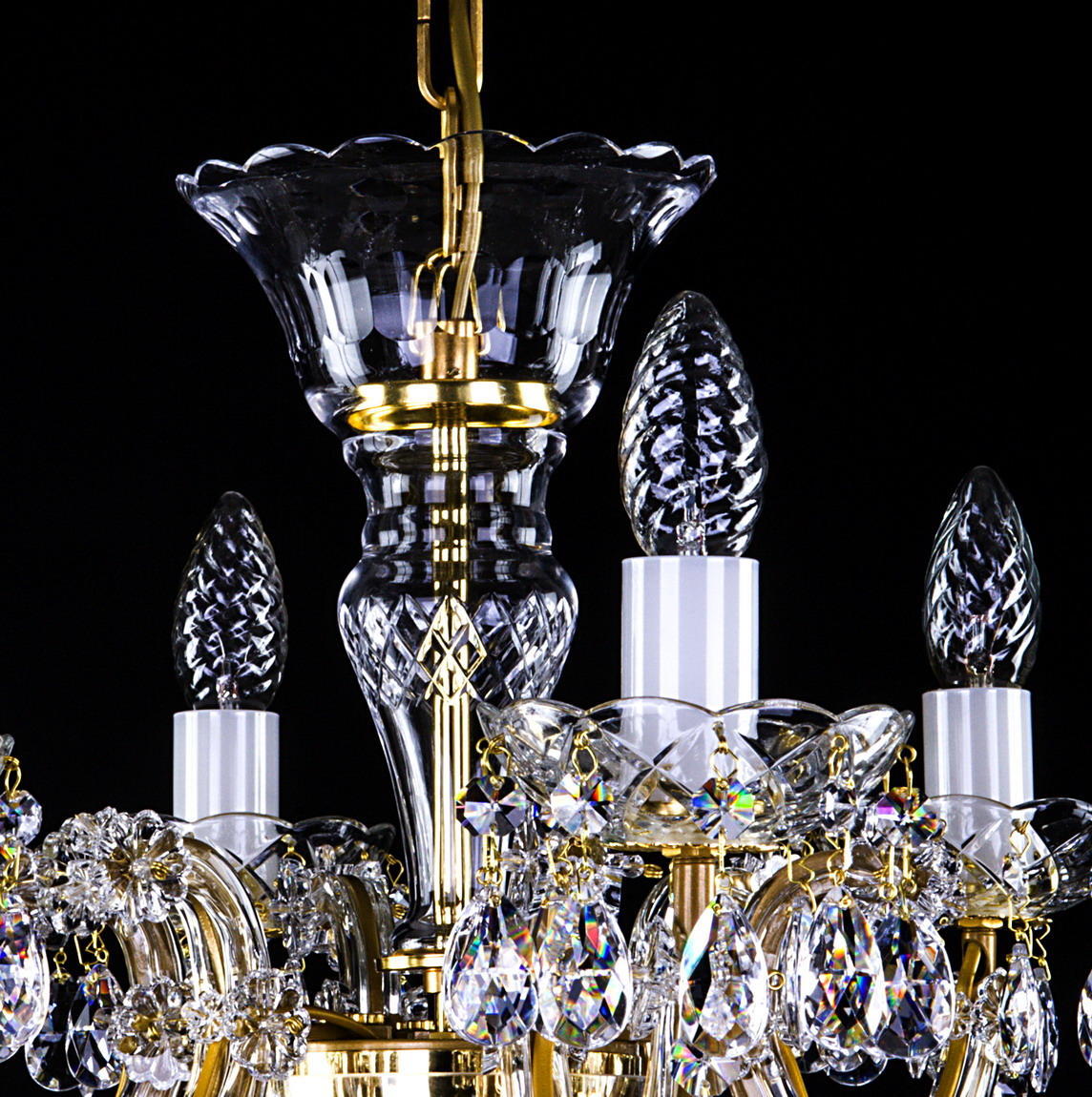 Détail du raccord central doré, tulipe de cristal et douilles blanches des bougies