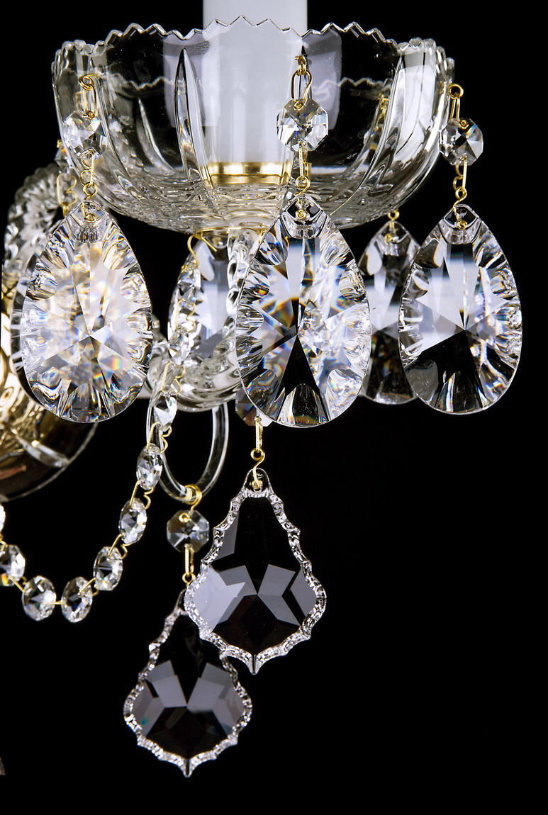 Détail des pendentifs en cristal taillé et des chaînettes dorées de l'applique murale.