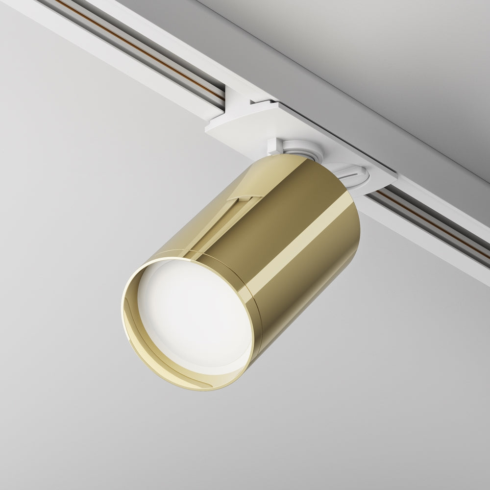 Vue de dessous d'un spot doré brillant sur rail blanc, diffuseur opale allumé