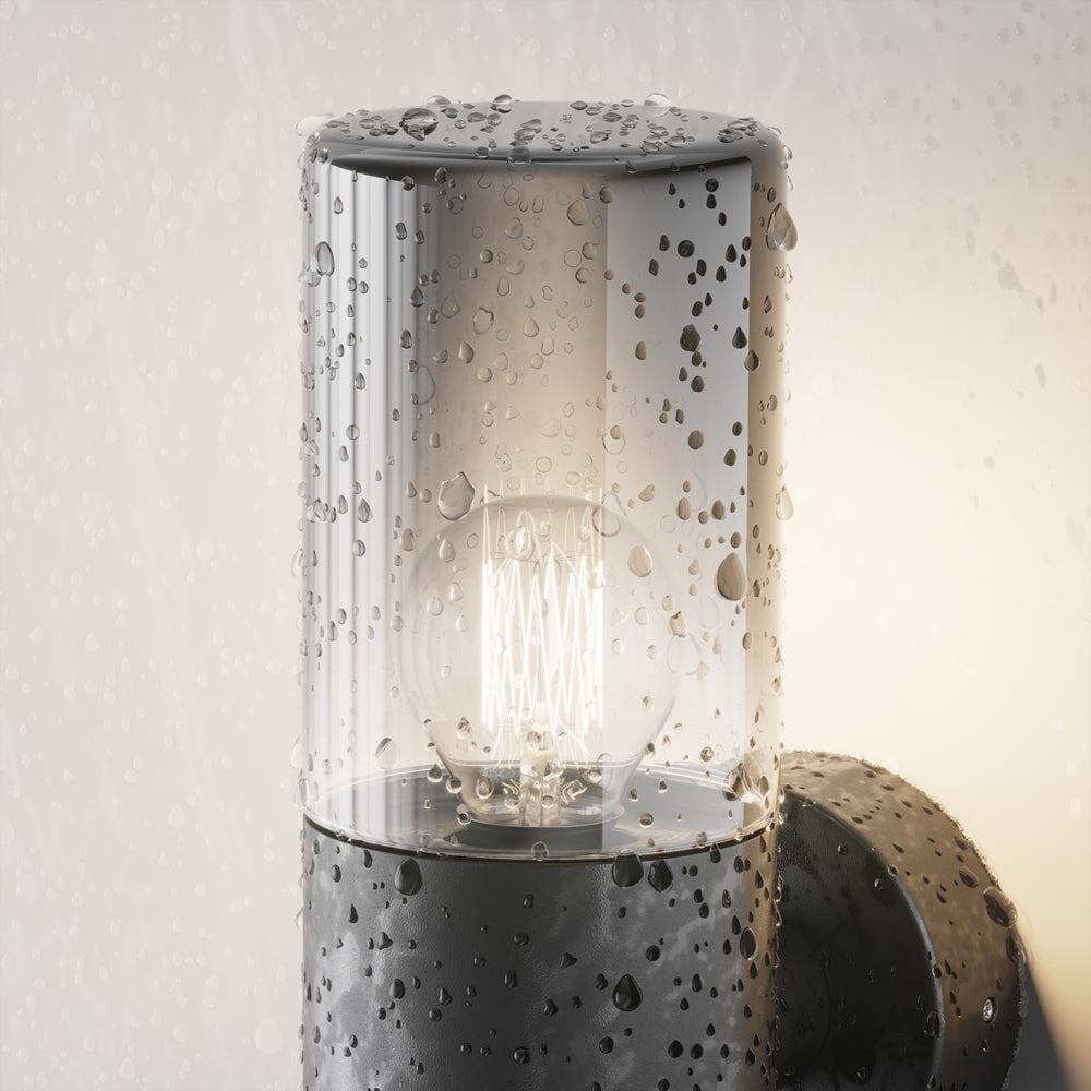 Détail du luminaire couvert de gouttes d'eau, résistance aux intempéries extérieures.