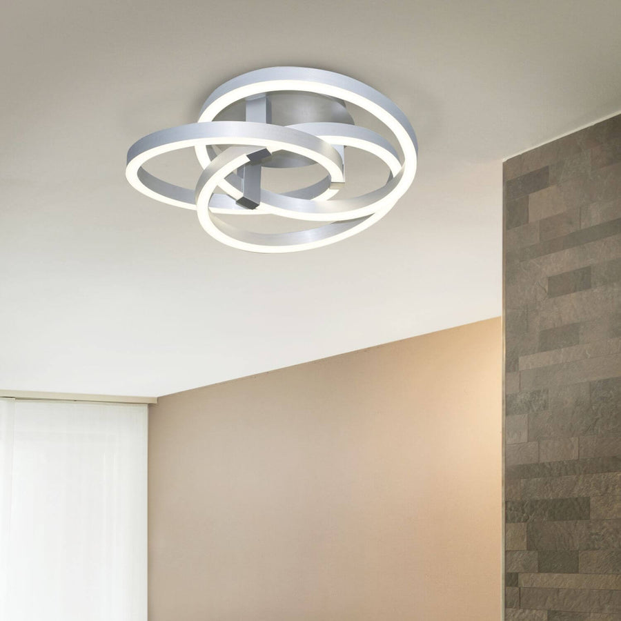 Luminaire allumé fixé au plafond d'une pièce aux murs taupe et parement de pierre