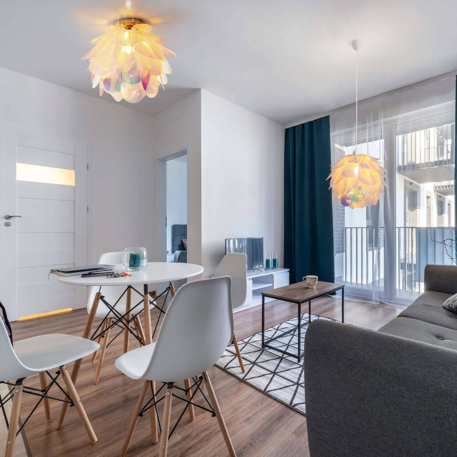 Plafonnier allumé au plafond et suspension identique près de la fenêtre.