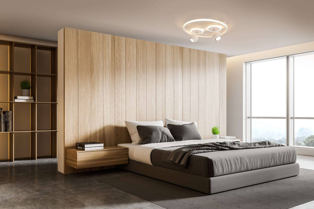 Mise en ambiance dans une chambre moderne, plafonnier allumé au-dessus du lit.