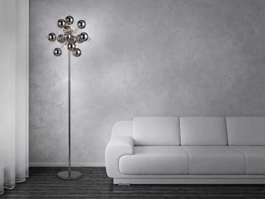 Lampadaire installé dans un salon, près d'un canapé blanc et mur gris.