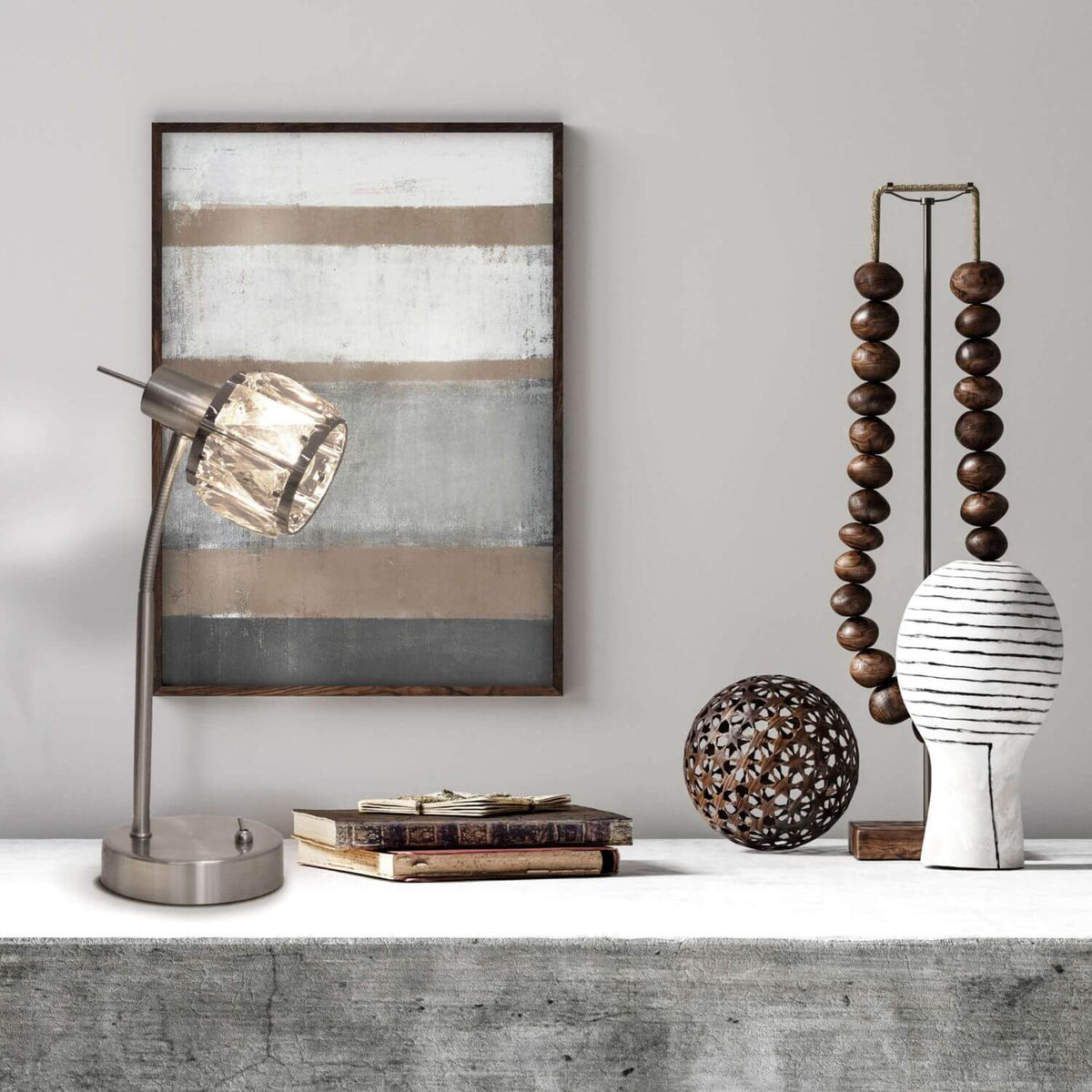 Mise en ambiance de la lampe posée sur une console avec cadre, livres et objets décoratifs.