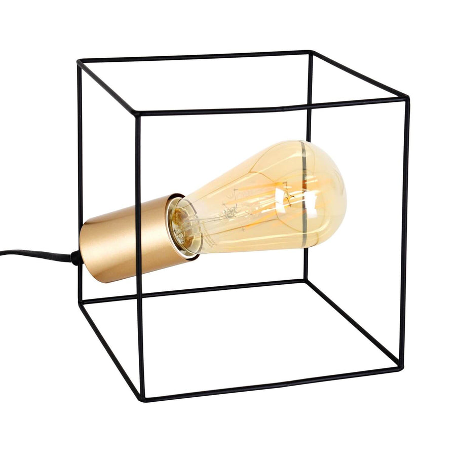 Lampe à poser noire cubique en métal avec ampoule dorée sur fond blanc.