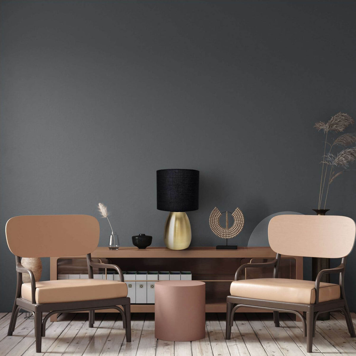 Mise en ambiance dans un salon sombre, lampe posée sur un meuble entre deux fauteuils beiges.