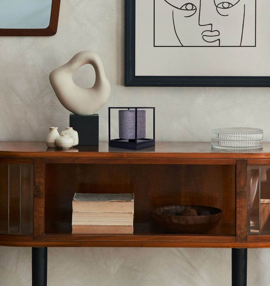 Vue rapprochée de la lampe posée sur un meuble en bois, dans un intérieur décoré.