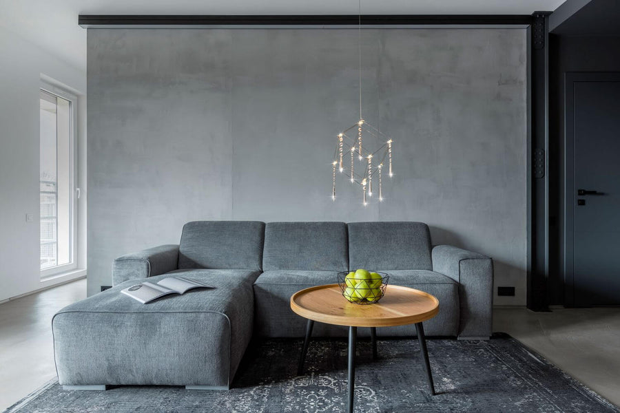 Suspension installée dans un salon gris au-dessus d'une table basse en bois
