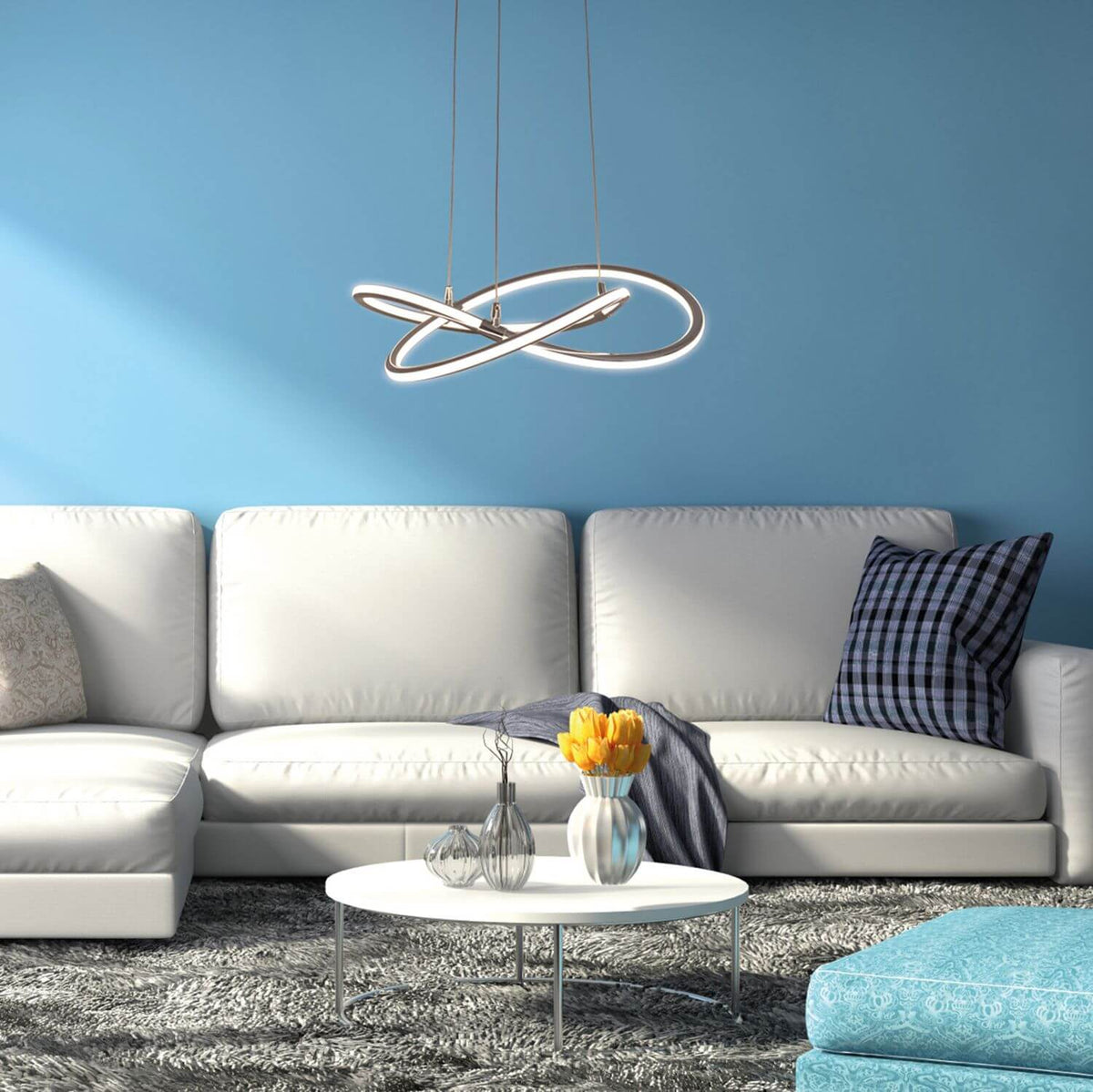 Mise en ambiance dans un salon bleu, canapé blanc et table basse sous le luminaire