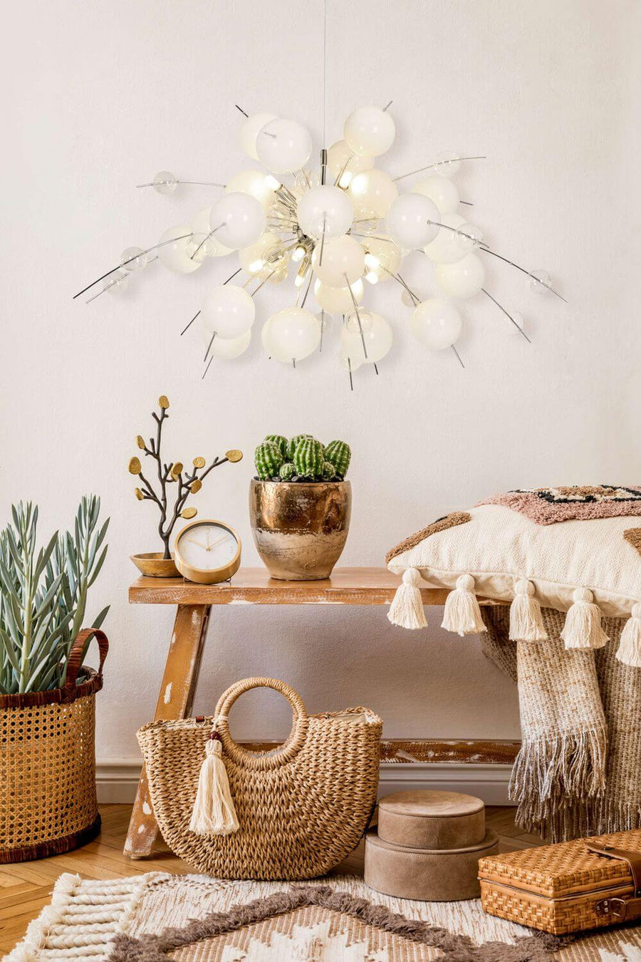 Mise en scène bohème du luminaire au-dessus d'une console en bois et d'accessoires tressés