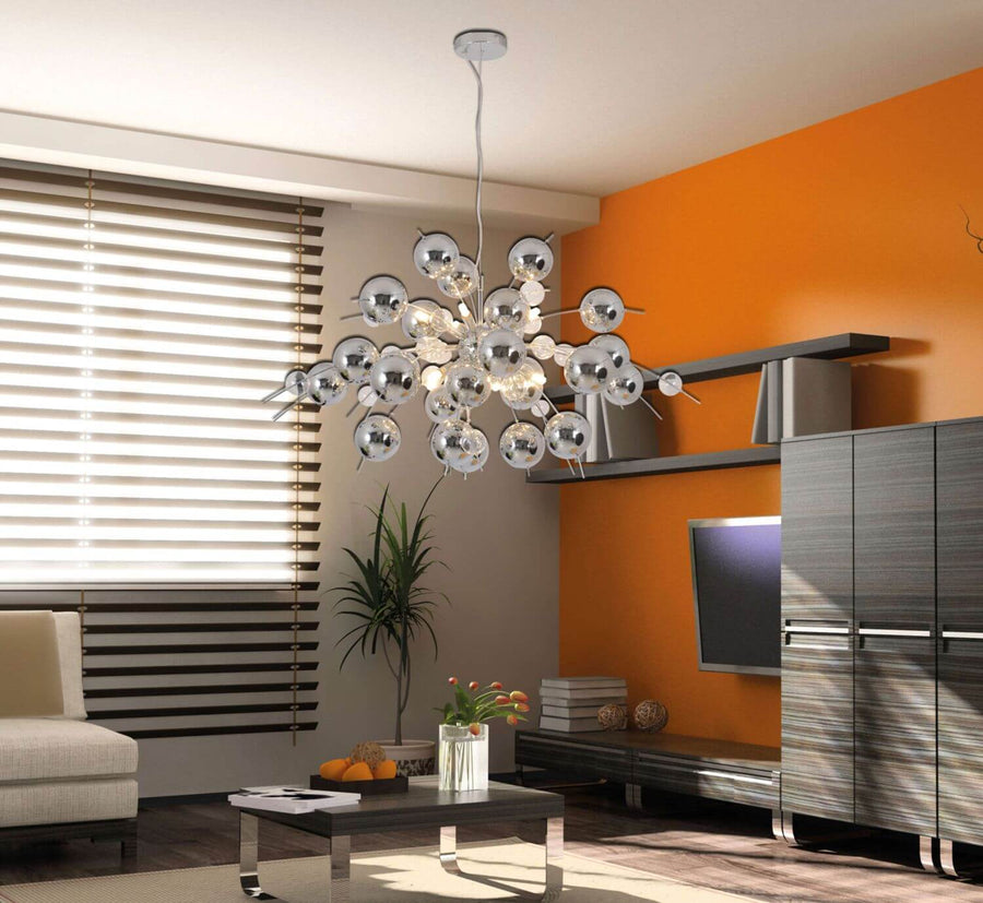 Vue rapprochée de la suspension chromée éclairée dans un séjour au mur orange.