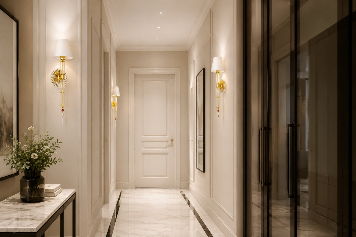 Couloir habillé de deux appliques dorées allumées encadrant une porte blanche