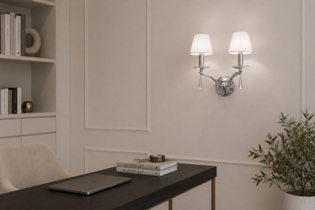 Ambiance bureau : applique chromée deux abat-jours au-dessus d'une table noire et livres.