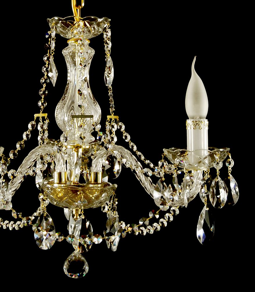 Détail du lustre : colonne torsadée, chaînes de cristal et bras dorés