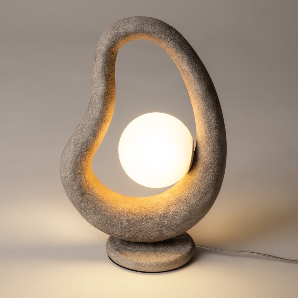 Vue de face du luminaire allumé, halo chaud soulignant l'intérieur de la boucle.