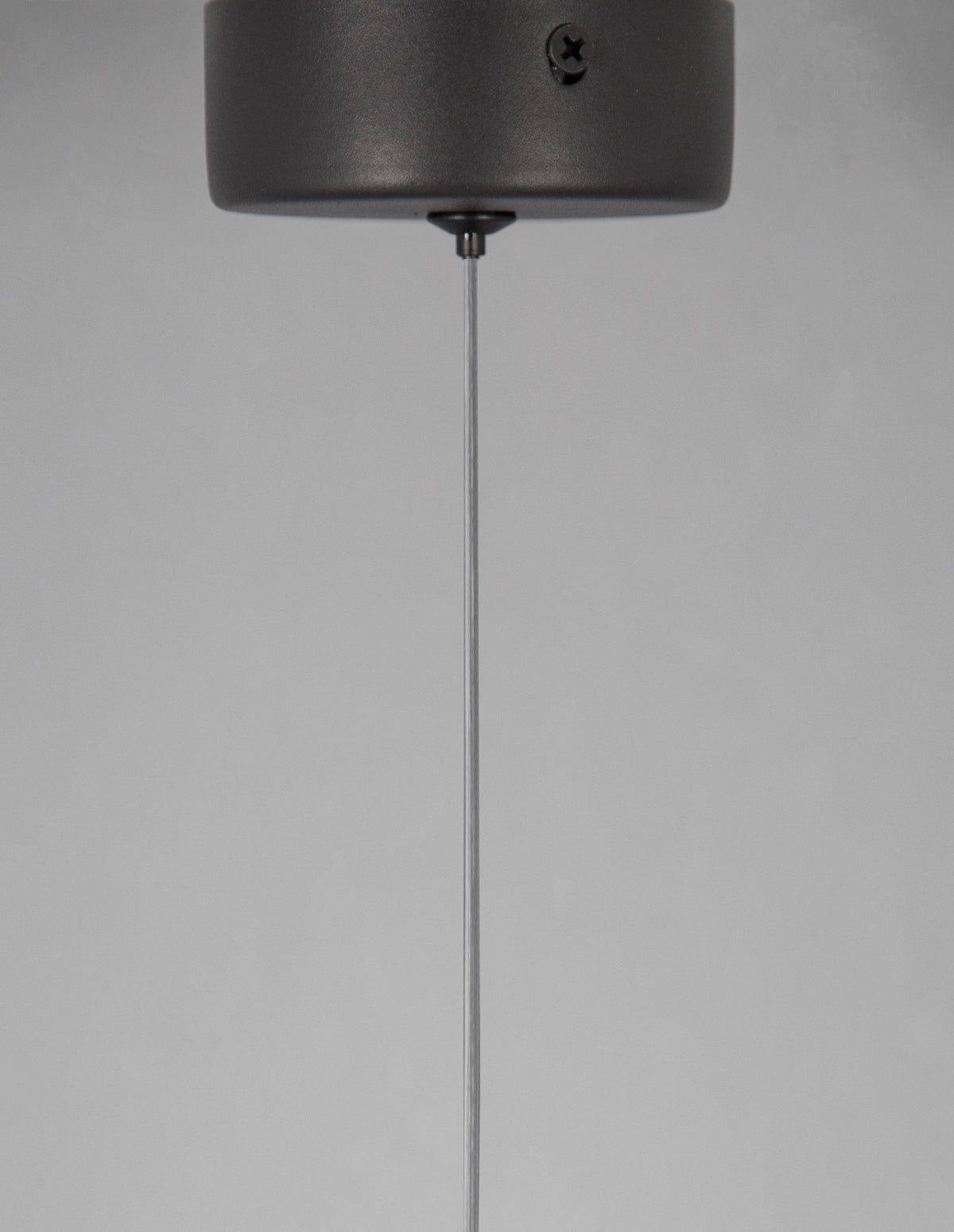 Détail de la base ronde noire fixée au plafond, vis apparente
