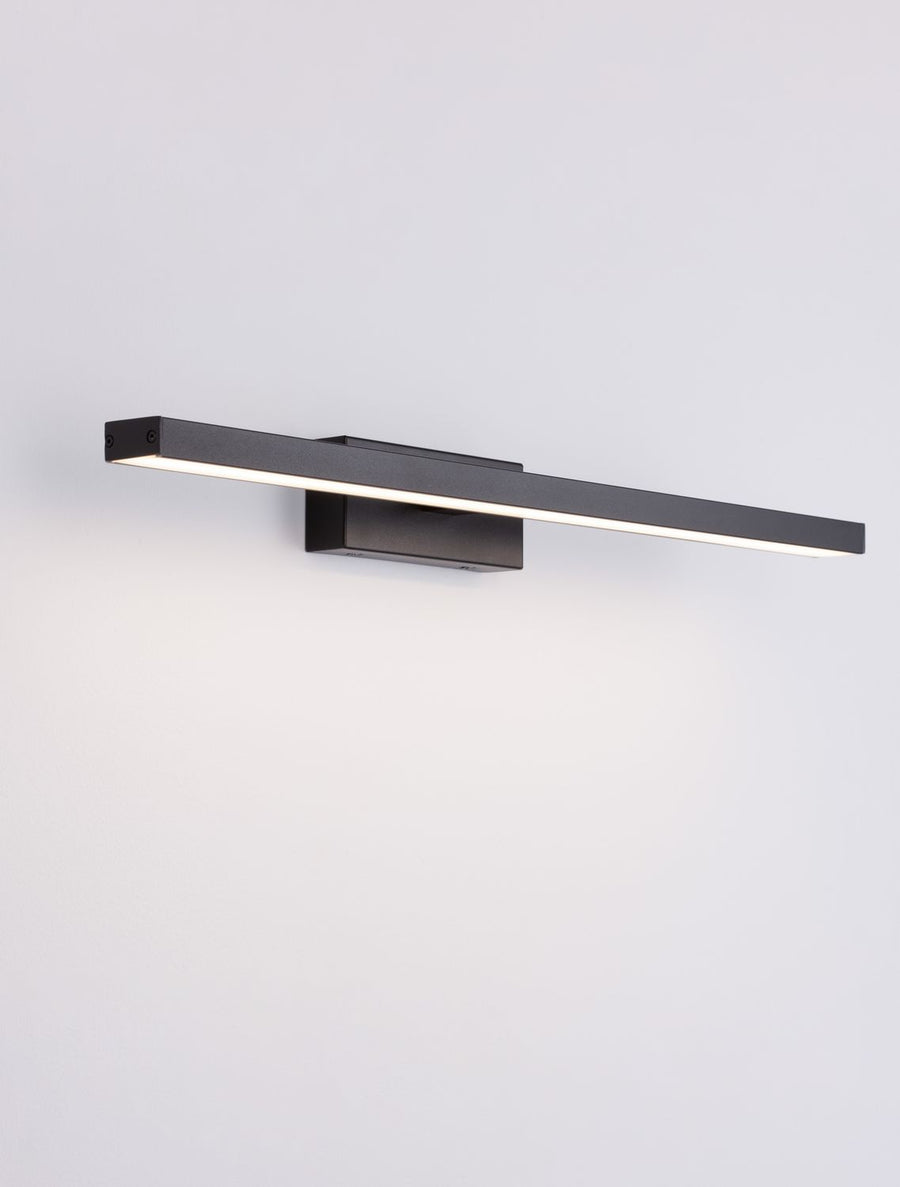 Vue trois quarts du luminaire allumé, longue bande LED en lumière rasante