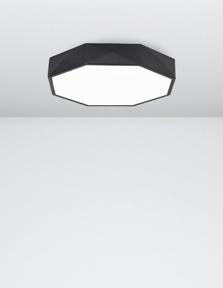Vue rapprochée du plafonnier allumé éclairant un plafond blanc uni