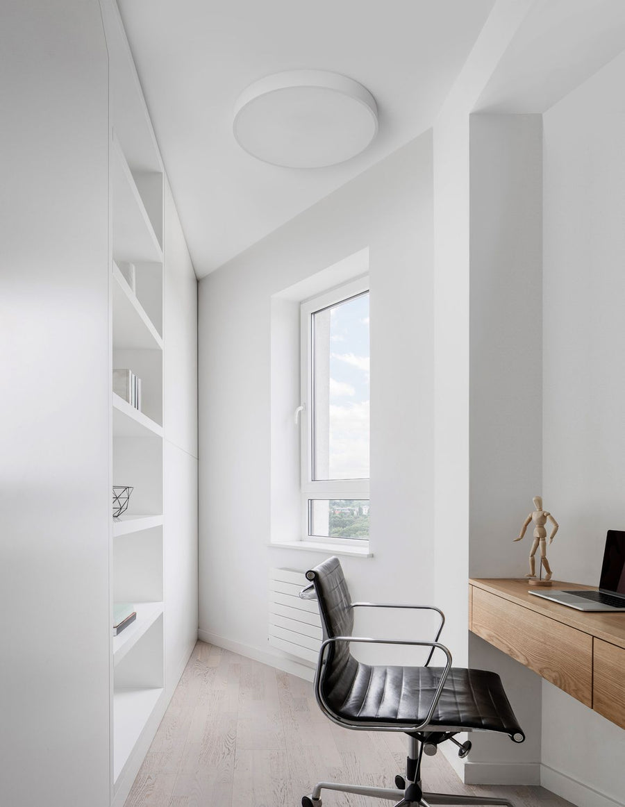 Vue d'ensemble du plafonnier rond blanc installé au plafond d'un bureau clair