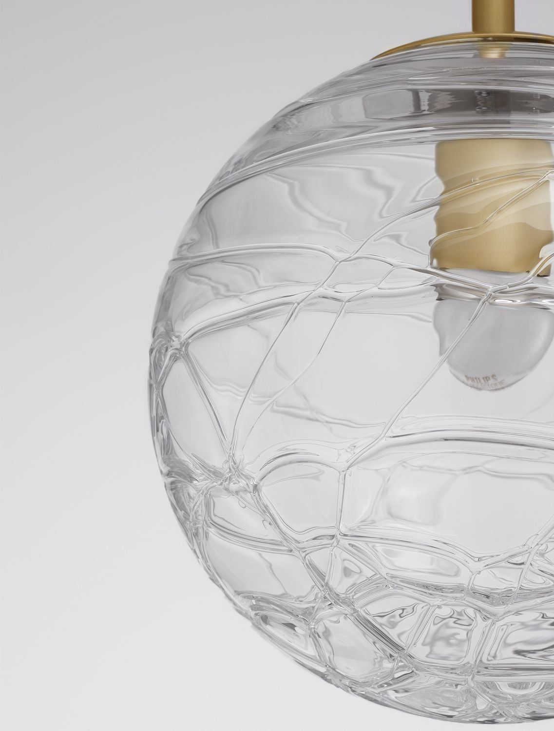 Détail rapproché du verre texturé en nid d'abeille et de la douille dorée