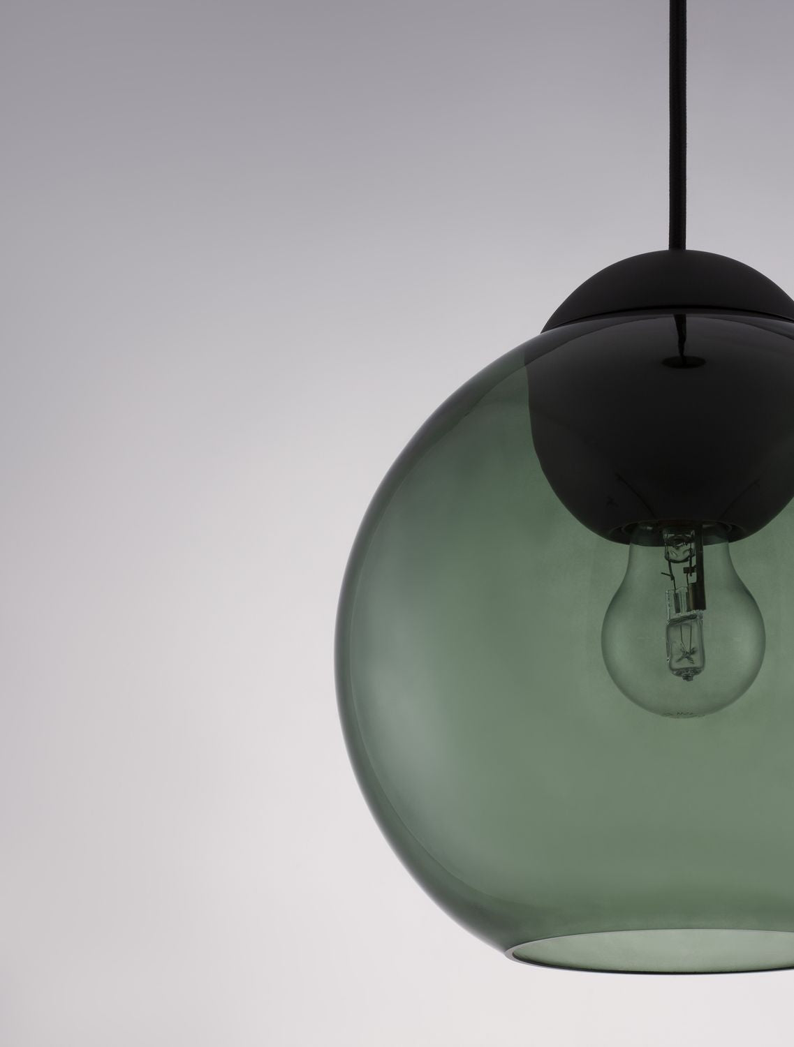 Gros plan sur la sphère de verre vert et sa douille noire fixée au câble