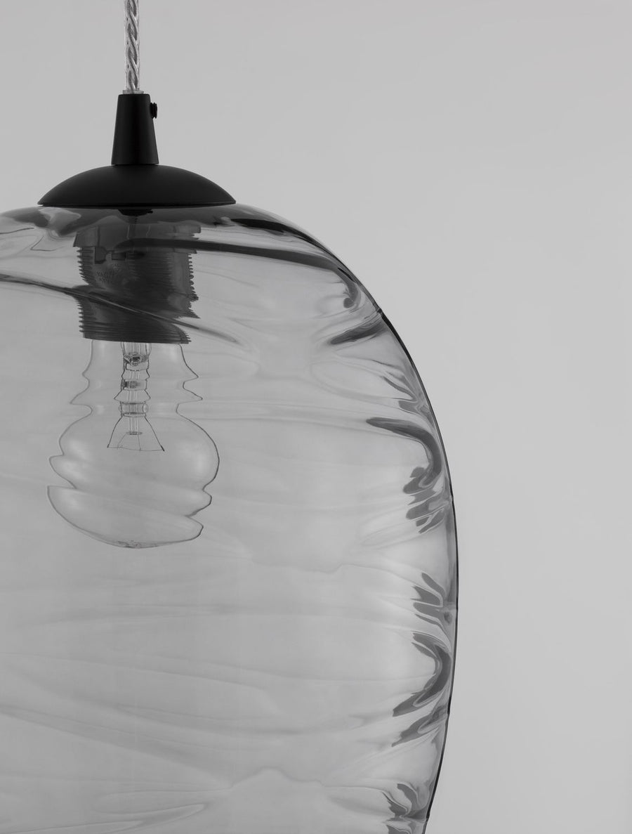 Gros plan sur la texture ondulée du verre et le raccord métallique noir