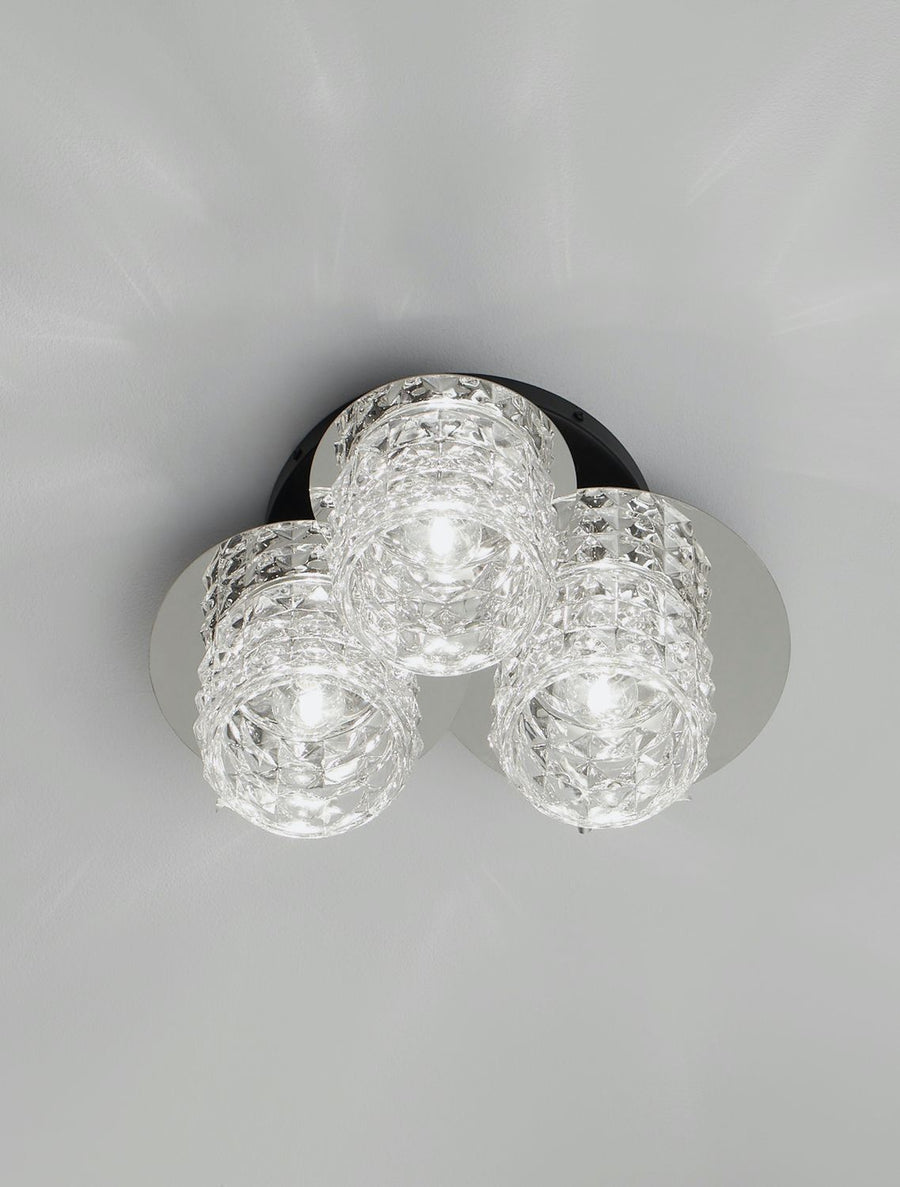 Plafonnier allumé, les trois cylindres de verre diffusent une lumière éclatante