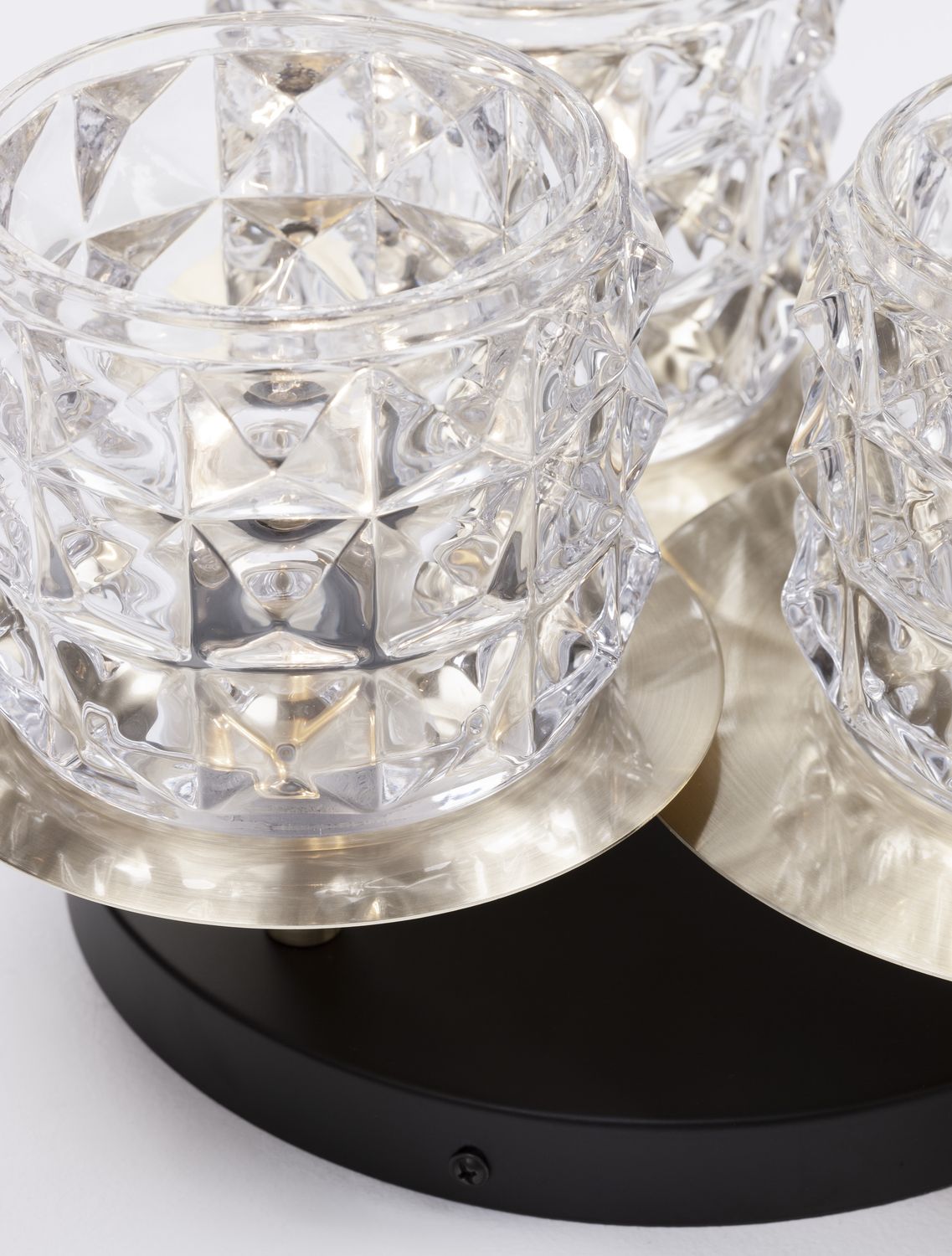 Détail des trois coupelles dorées et verres facettés vus de trois quarts