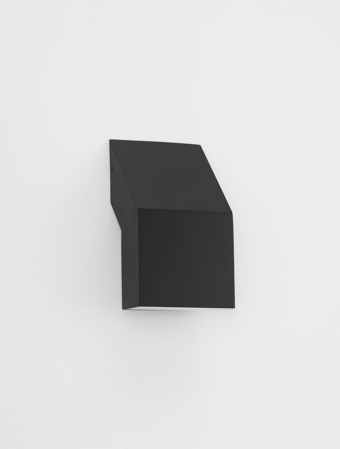 Applique murale noire installée sur un mur blanc, vue latérale