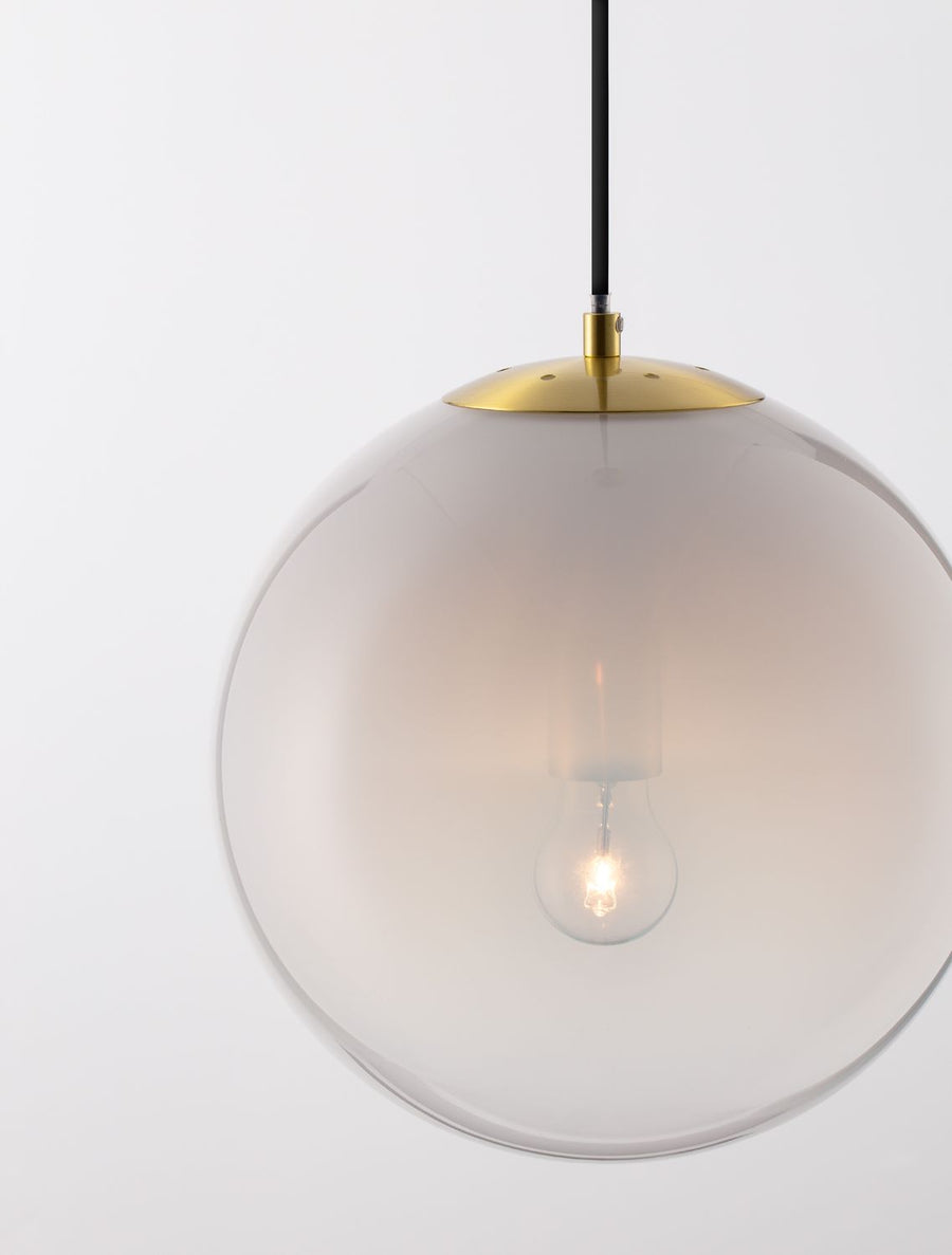 Détail du globe en verre et de la calotte dorée avec l'ampoule qui s'illumine