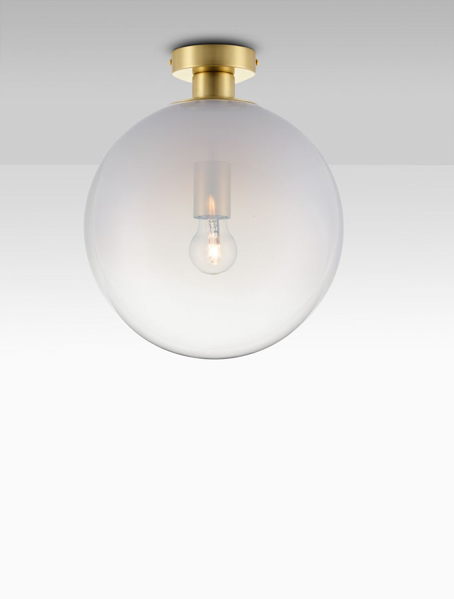 Plafonnier doré à globe de verre dépoli allumé, vu de face sous un plafond blanc