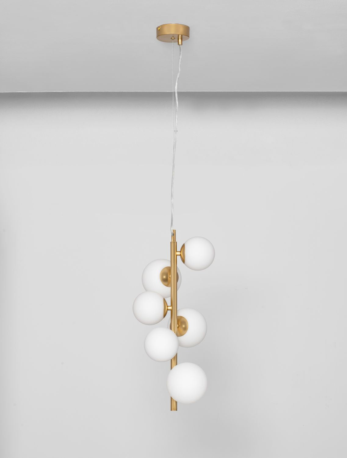 Suspension dorée à six globes de verre blanc, vue d'ensemble sur fond neutre.