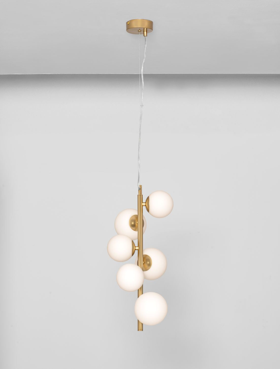 Luminaire suspendu doré à six globes opalins, photographié en intérieur clair.