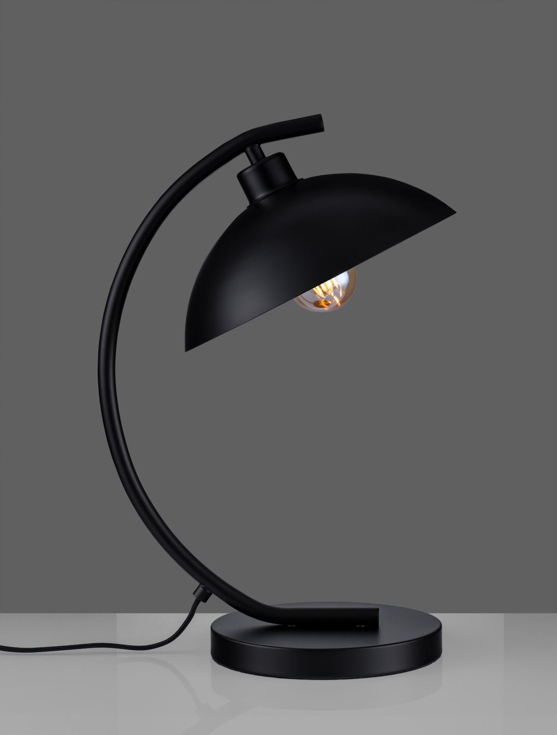 Même lampe noire sur fond gris, éclairage éteint, câble d'alimentation visible à gauche.