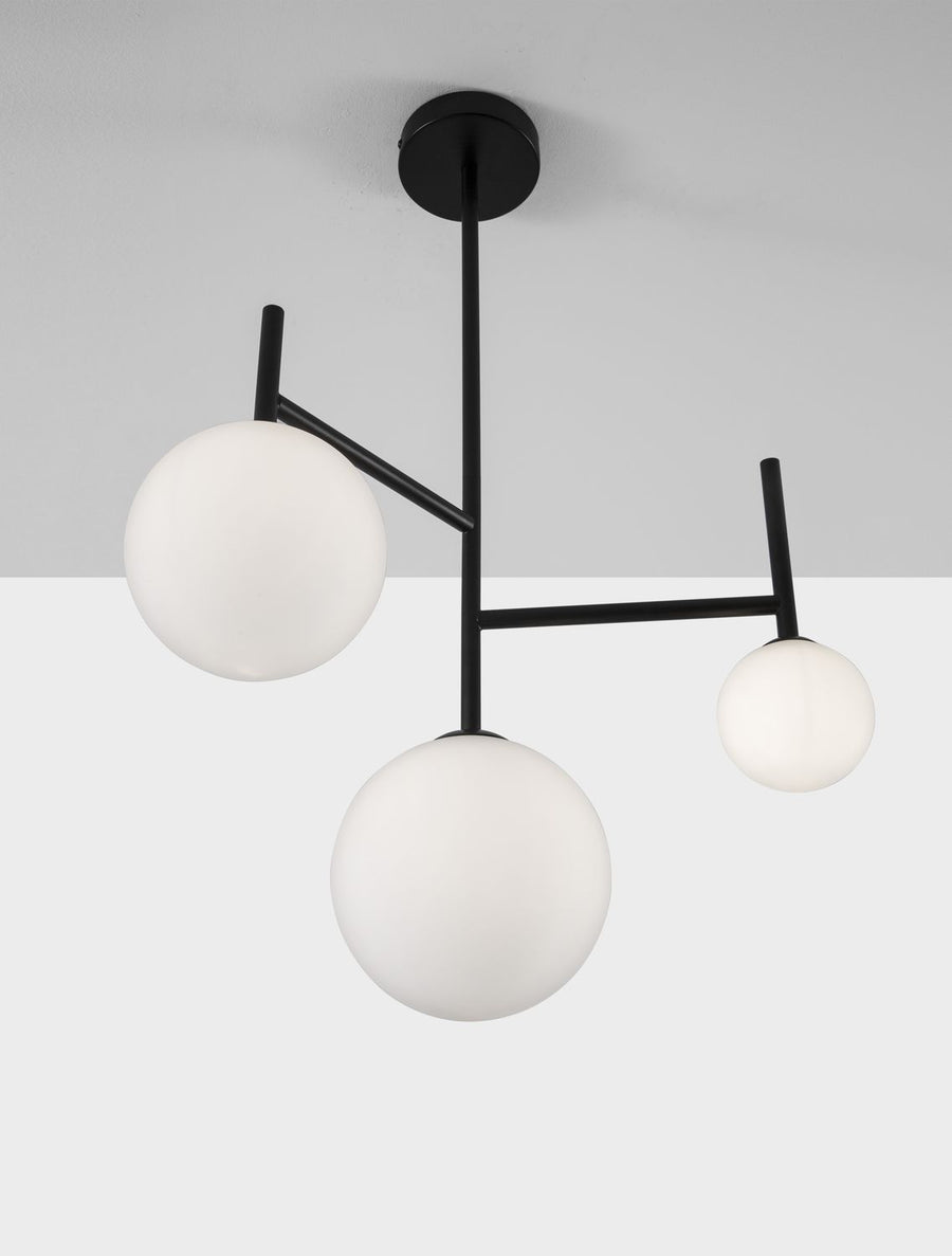 Gros plan du luminaire montrant la fixation plafond, la tige et les trois globes