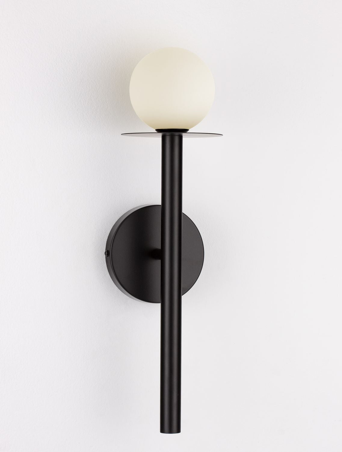 Photo du luminaire allumé, globe en verre diffusant une lumière chaude