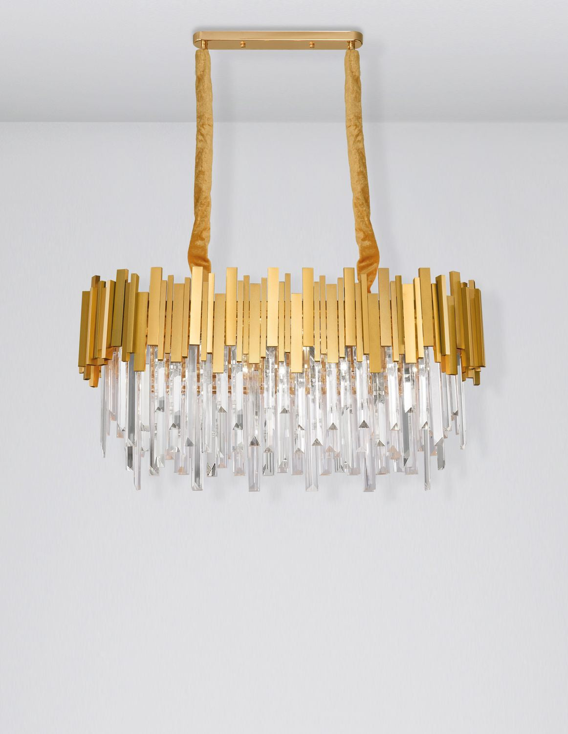 Vue rapprochée du luminaire, baguettes dorées et prismes de cristal suspendus
