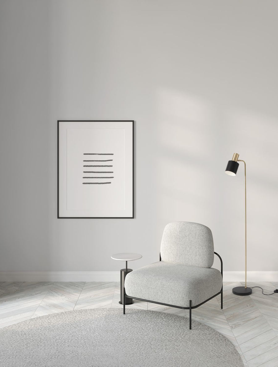 Lampadaire doré installé près d'un fauteuil gris dans un salon clair contemporain