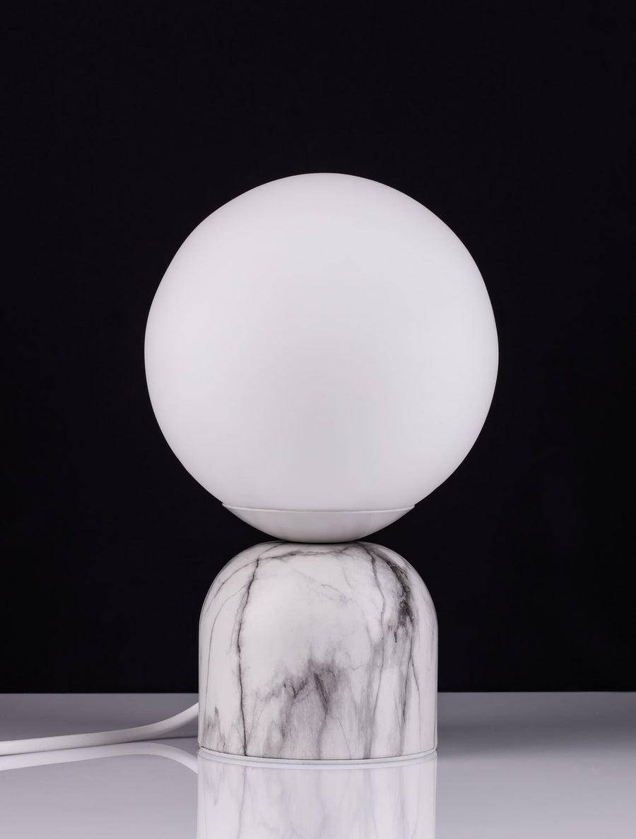 Vue de face sur fond noir, reflet du socle en marbre sur la surface brillante.