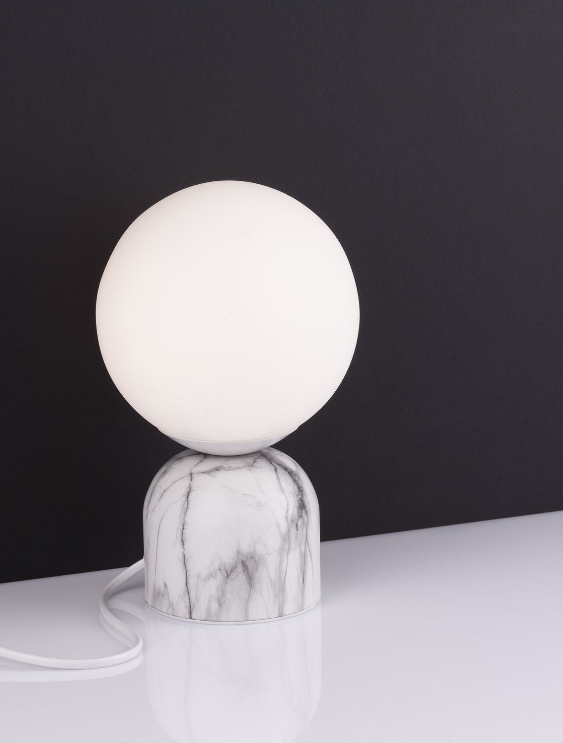 Détail du raccord entre la sphère lumineuse et le socle en marbre marbré.