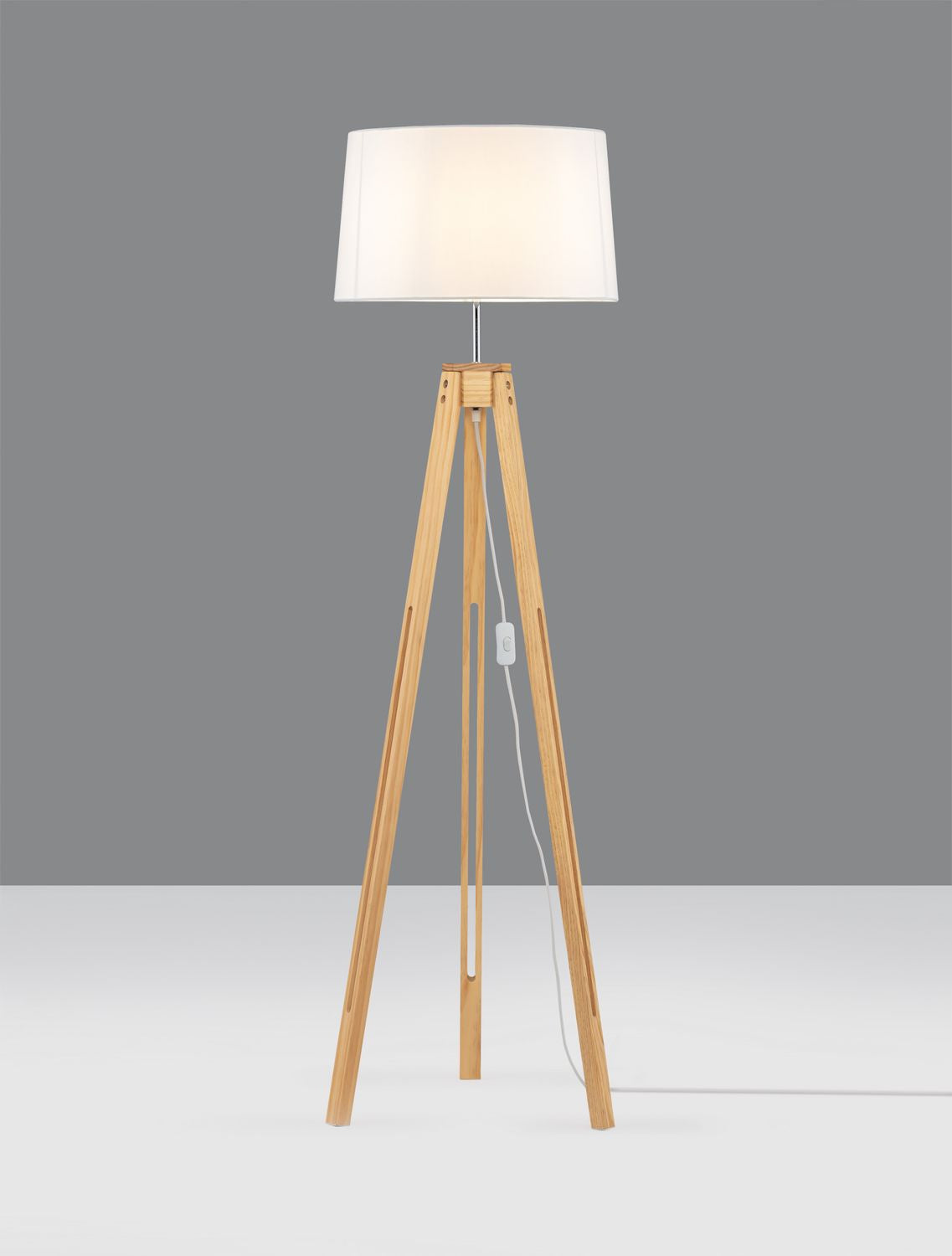Lampadaire trépied en bois allumé, diffusant une lumière chaude dans la pièce