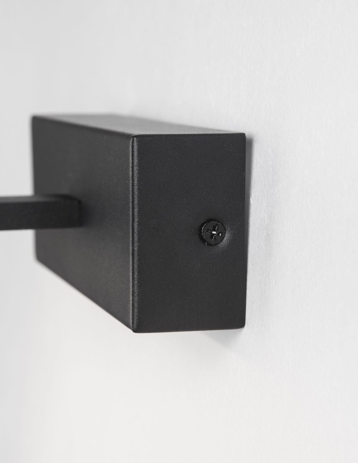 Détail du socle rectangulaire noir fixé au mur par une vis apparente