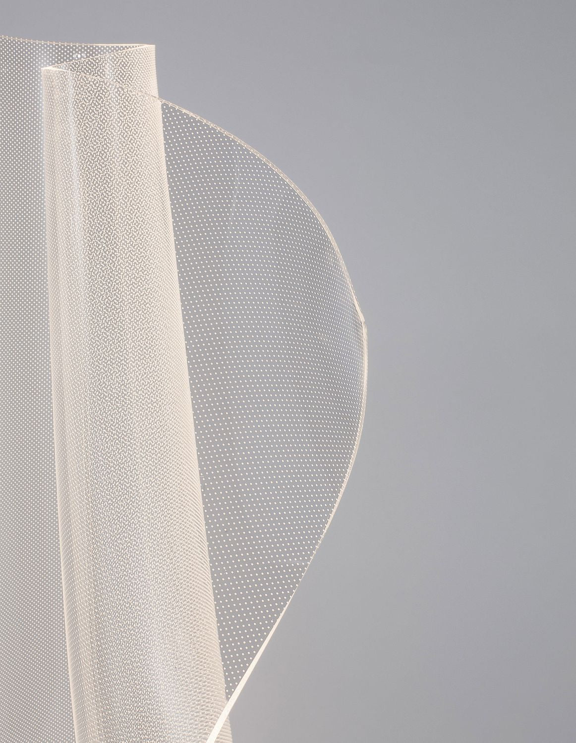 Détail de la matière perforée du diffuseur, courbes superposées et points lumineux.