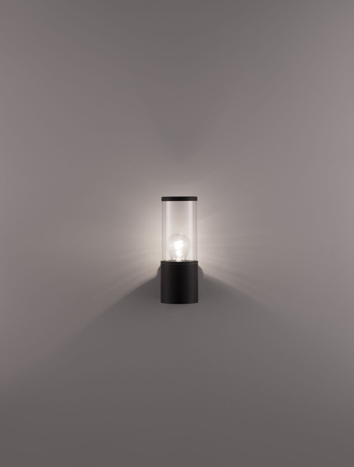 Mise en ambiance nocturne, l'applique diffuse une lumière chaude sur le mur
