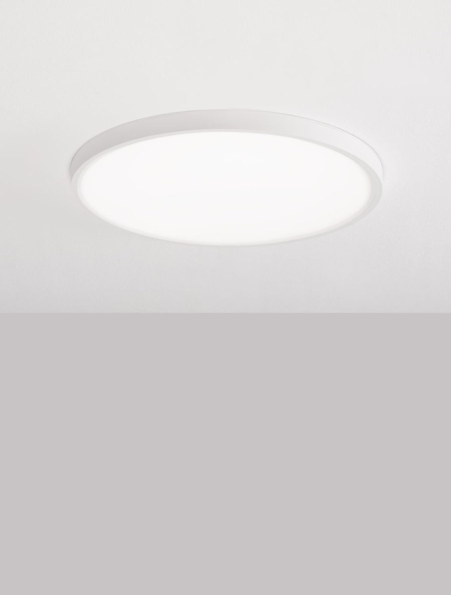 Plafonnier rond blanc allumé diffusant une lumière douce et homogène