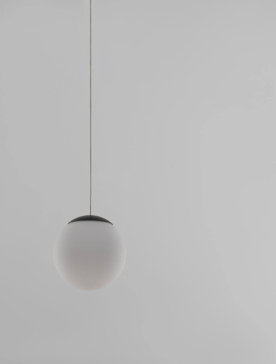 Détail de la sphère en verre blanc éteinte, capuchon supérieur noir et câble fin