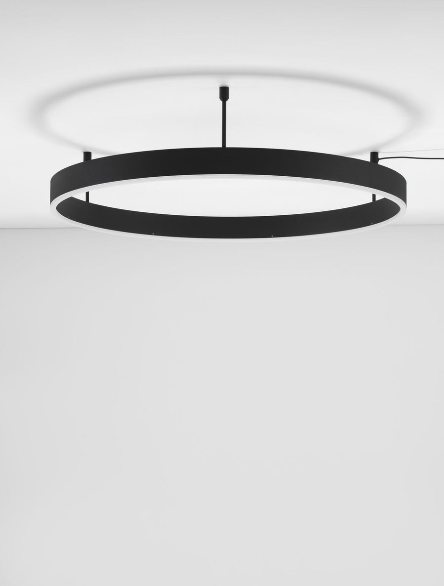 Plafonnier anneau noir de face, diffusant une lumière blanche sur le plafond