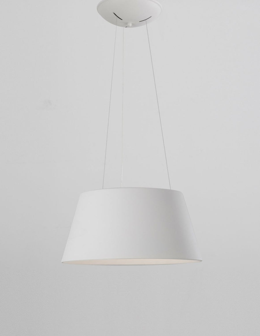 Vue légèrement inclinée de la suspension blanche, abat-jour conique et câbles fins.