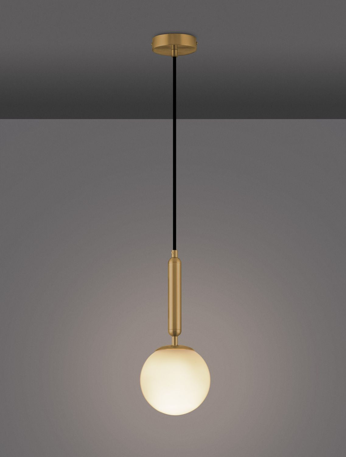 Le luminaire allumé sur fond gris foncé, diffusant une lumière chaude à travers le verre.